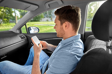 Image showing male passenger using smartphone in taxi car