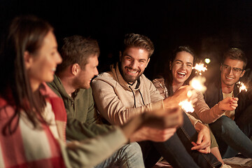 Image showing happy friends with sparklers at night outdoors