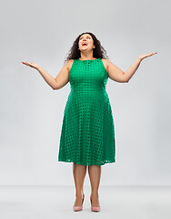 Image showing happy smiling woman in green dress looking up