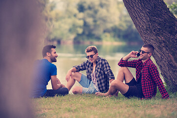 Image showing men sitting on the bank of the river