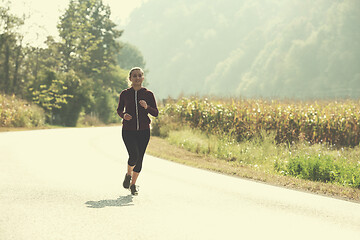 Image showing woman jogging along a country road