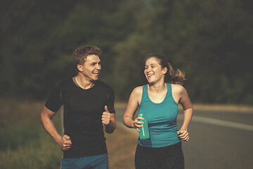 Image showing young couple jogging along a country road