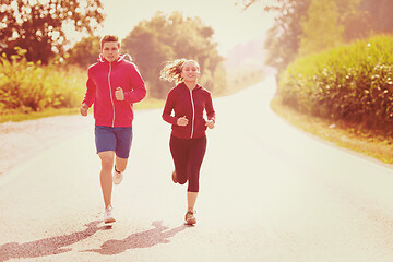 Image showing young couple jogging along a country road