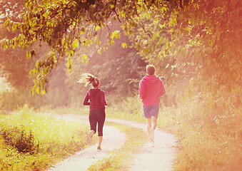 Image showing young couple jogging along a country road