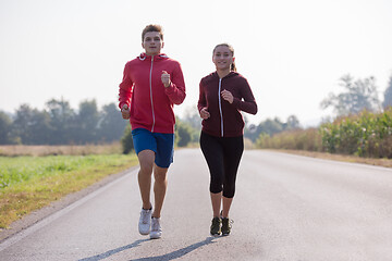 Image showing young couple jogging along a country road