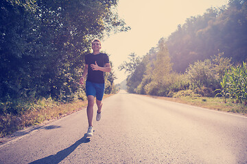 Image showing man jogging along a country road