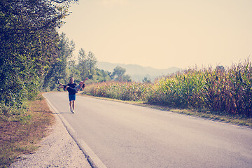 Image showing happy couple jogging along a country road
