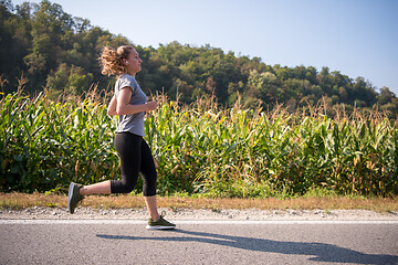 Image showing woman jogging along a country road