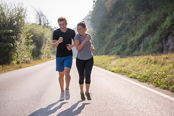 Image showing young couple jogging along a country road