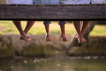 Image showing people sitting at wooden bridge