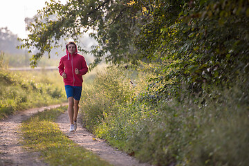 Image showing man jogging along a country road