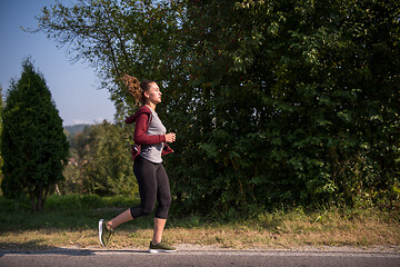 Image showing woman jogging along a country road