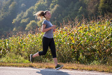 Image showing woman jogging along a country road