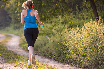 Image showing woman jogging along a country road