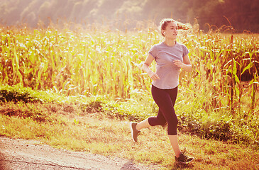 Image showing woman jogging along a country road