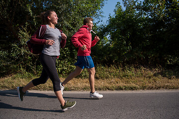 Image showing young couple jogging along a country road