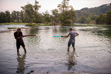 Image showing young men having fun with water guns