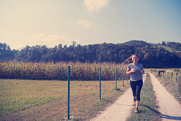 Image showing woman jogging along a country road