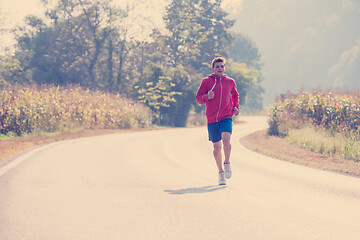 Image showing man jogging along a country road