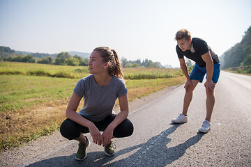 Image showing young couple warming up and stretching on a country road