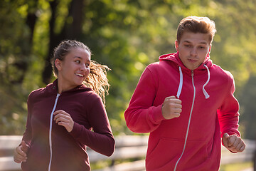 Image showing young couple jogging along a country road