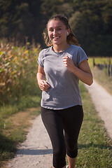 Image showing woman jogging along a country road