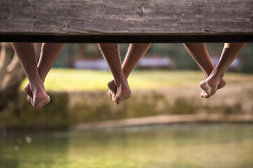 Image showing people sitting at wooden bridge