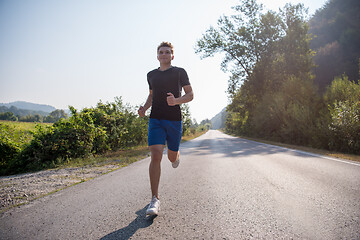 Image showing man jogging along a country road