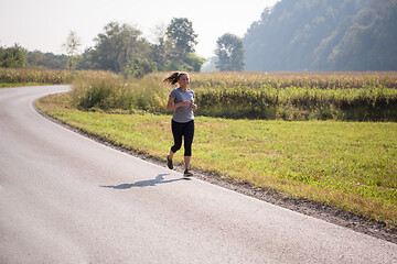 Image showing woman jogging along a country road