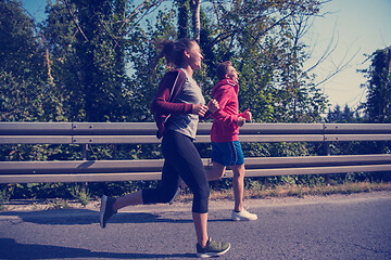 Image showing young couple jogging along a country road