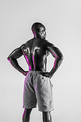 Image showing Young african-american bodybuilder training over grey background