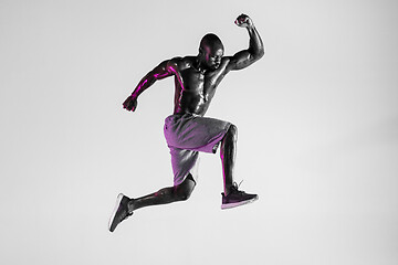 Image showing Young african-american bodybuilder training over grey background