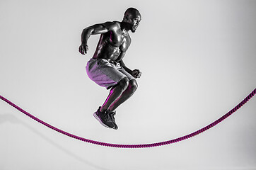 Image showing Young african-american bodybuilder training over grey background