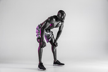 Image showing Young african-american bodybuilder training over grey background