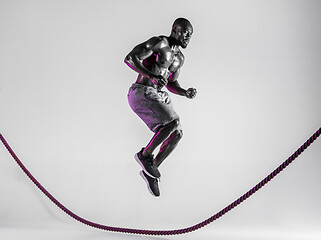 Image showing Young african-american bodybuilder training over grey background