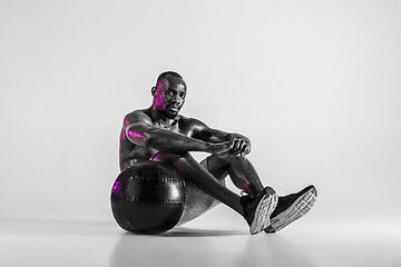 Image showing Young african-american bodybuilder training over grey background