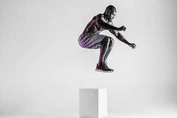 Image showing Young african-american bodybuilder training over grey background