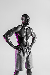 Image showing Young african-american bodybuilder training over grey background