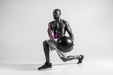 Image showing Young african-american bodybuilder training over grey background