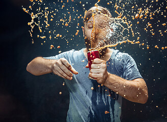 Image showing Man drinking a cola and enjoying the spray.