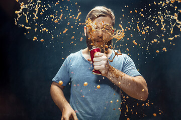 Image showing Man drinking a cola and enjoying the spray.