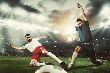 Image showing Two men are playing soccer and they compete with each other