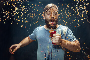 Image showing Man drinking a cola and enjoying the spray.