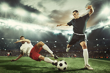 Image showing Two men are playing soccer and they compete with each other