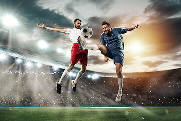 Image showing Two men are playing soccer and they compete with each other