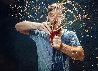 Image showing Man drinking a cola and enjoying the spray.