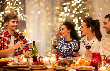 Image showing happy friends drinking red wine at christmas party