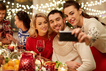 Image showing friends having christmas dinner and taking selfie