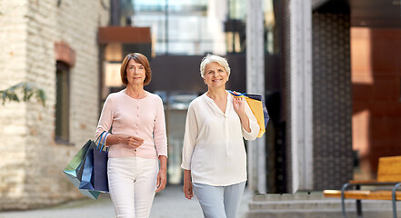 Image showing senior women with shopping bags walking in city