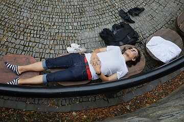 Image showing Man lying on a park bench in summer